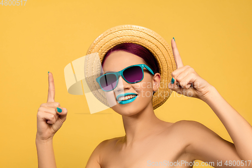 Image of Portrait of beautiful young woman with bright make-up isolated on yellow studio background