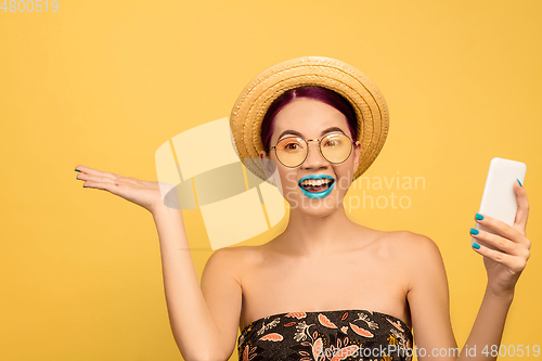 Image of Portrait of beautiful young woman with bright make-up isolated on yellow studio background