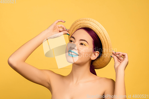 Image of Portrait of beautiful young woman with bright make-up isolated on yellow studio background