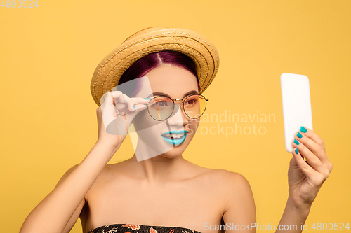 Image of Portrait of beautiful young woman with bright make-up isolated on yellow studio background