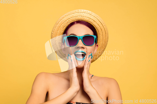 Image of Portrait of beautiful young woman with bright make-up isolated on yellow studio background