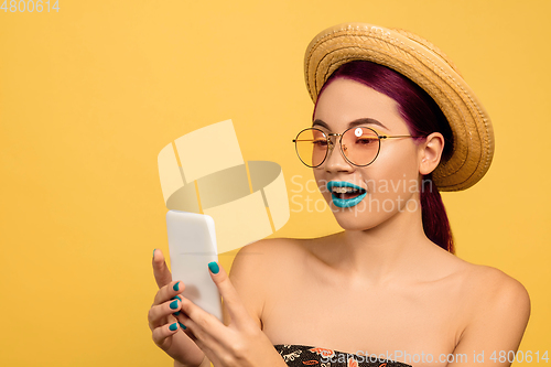 Image of Portrait of beautiful young woman with bright make-up isolated on yellow studio background