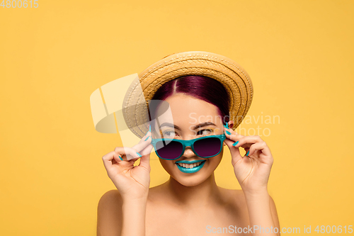 Image of Portrait of beautiful young woman with bright make-up isolated on yellow studio background