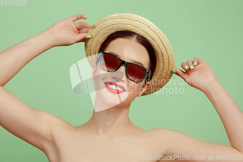 Image of Portrait of beautiful young woman with bright make-up isolated on green studio background