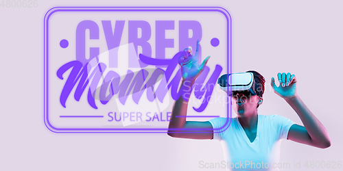 Image of Half-length close up portrait of young woman in neon light with cyber monday lettering