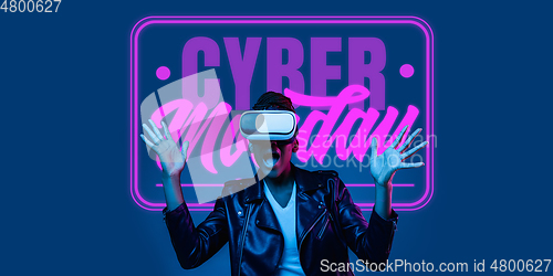 Image of Half-length close up portrait of young woman in neon light with cyber monday lettering