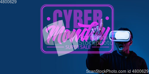 Image of Half-length close up portrait of young man in neon light with cyber monday lettering