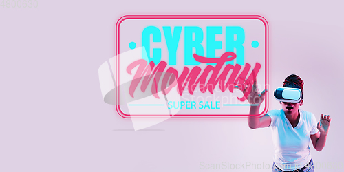 Image of Half-length close up portrait of young woman in neon light with cyber monday lettering