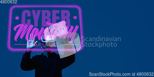 Image of Half-length close up portrait of young man in neon light with cyber monday lettering