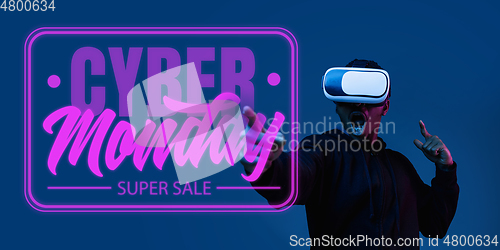 Image of Half-length close up portrait of young man in neon light with cyber monday lettering