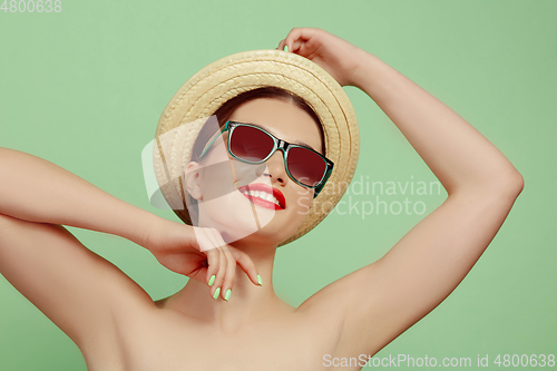 Image of Portrait of beautiful young woman with bright make-up isolated on green studio background