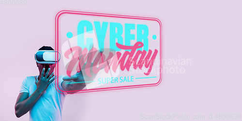 Image of Half-length close up portrait of young man in neon light with cyber monday lettering