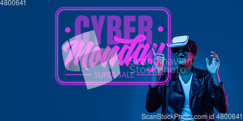 Image of Half-length close up portrait of young woman in neon light with cyber monday lettering