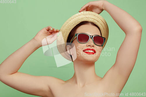 Image of Portrait of beautiful young woman with bright make-up isolated on green studio background