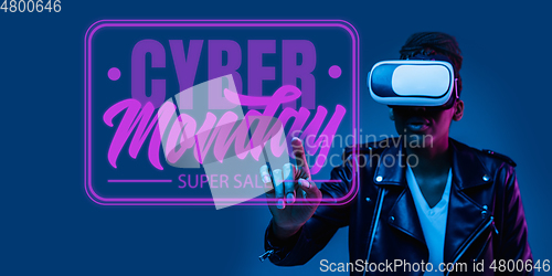 Image of Half-length close up portrait of young woman in neon light with cyber monday lettering