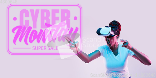 Image of Half-length close up portrait of young woman in neon light with cyber monday lettering