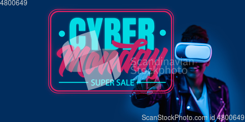 Image of Half-length close up portrait of young woman in neon light with cyber monday lettering