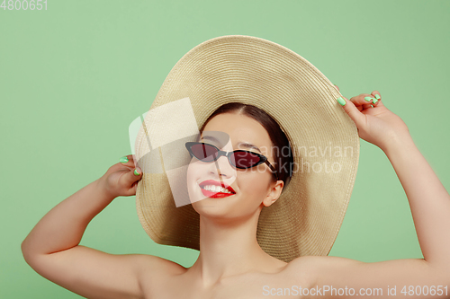 Image of Portrait of beautiful young woman with bright make-up isolated on green studio background