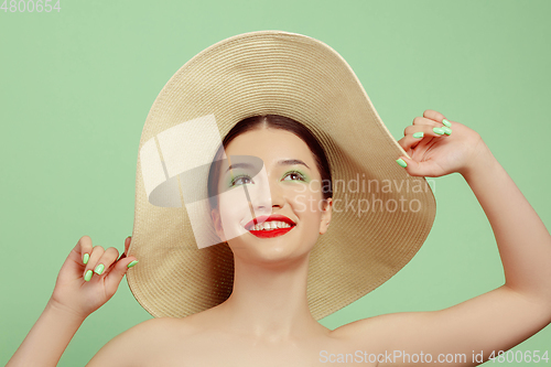 Image of Portrait of beautiful young woman with bright make-up isolated on green studio background