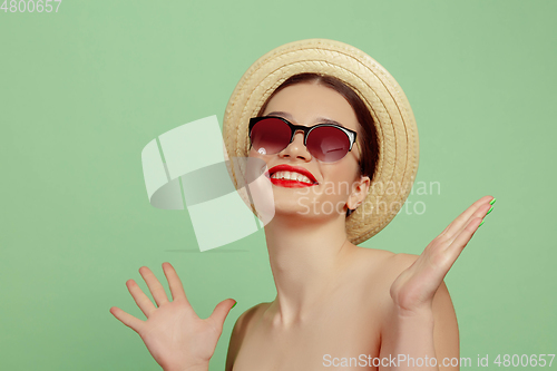 Image of Portrait of beautiful young woman with bright make-up isolated on green studio background