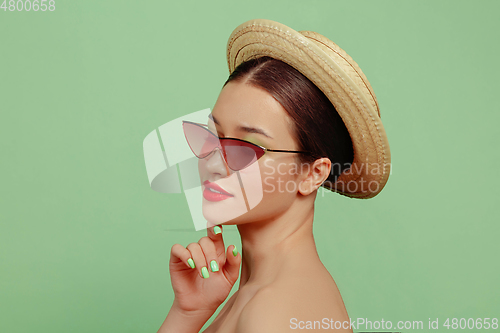 Image of Portrait of beautiful young woman with bright make-up isolated on green studio background