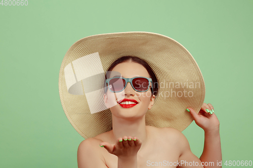 Image of Portrait of beautiful young woman with bright make-up isolated on green studio background