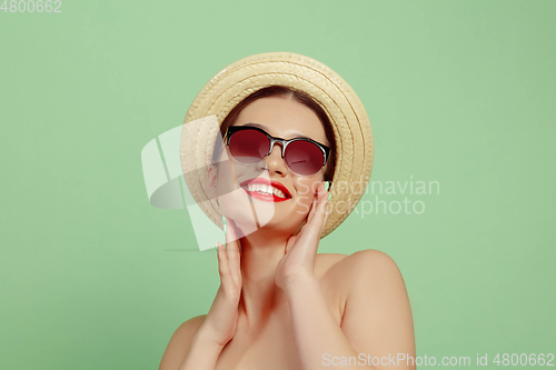 Image of Portrait of beautiful young woman with bright make-up isolated on green studio background