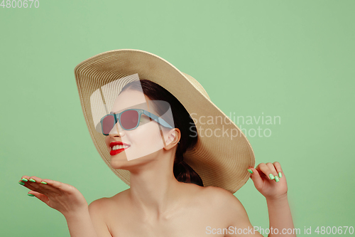 Image of Portrait of beautiful young woman with bright make-up isolated on green studio background