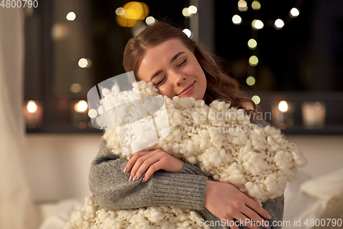 Image of happy young woman with soft pillow in bed at home