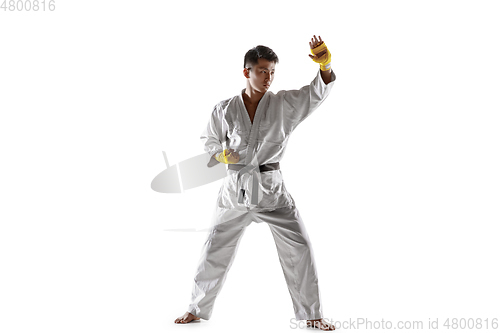 Image of Confident korean man in kimono practicing hand-to-hand combat, martial arts