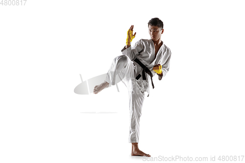 Image of Confident korean man in kimono practicing hand-to-hand combat, martial arts