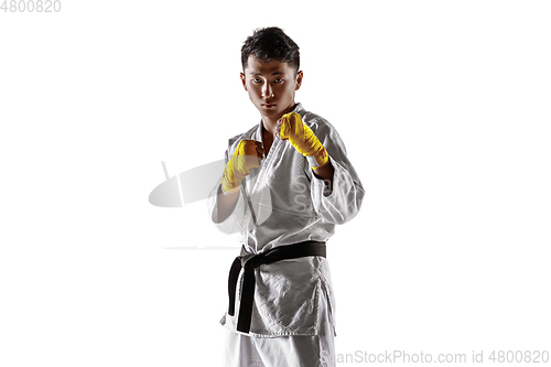 Image of Confident korean man in kimono practicing hand-to-hand combat, martial arts