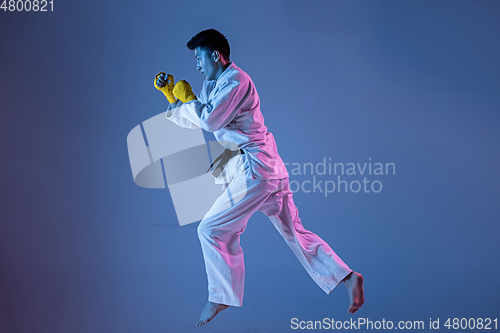 Image of Confident korean man in kimono practicing hand-to-hand combat, martial arts