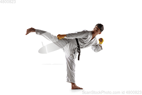 Image of Confident korean man in kimono practicing hand-to-hand combat, martial arts