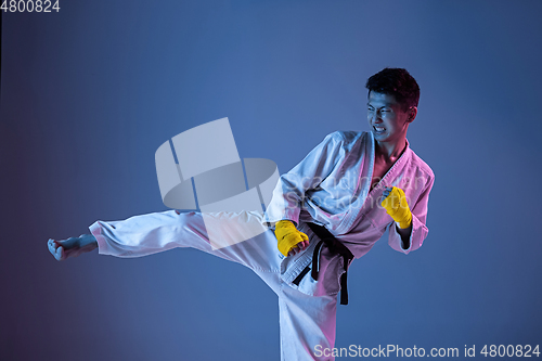 Image of Confident korean man in kimono practicing hand-to-hand combat, martial arts