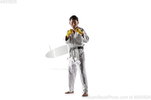 Image of Confident korean man in kimono practicing hand-to-hand combat, martial arts