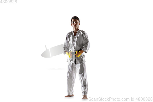 Image of Confident korean man in kimono practicing hand-to-hand combat, martial arts