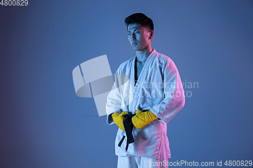 Image of Confident korean man in kimono practicing hand-to-hand combat, martial arts