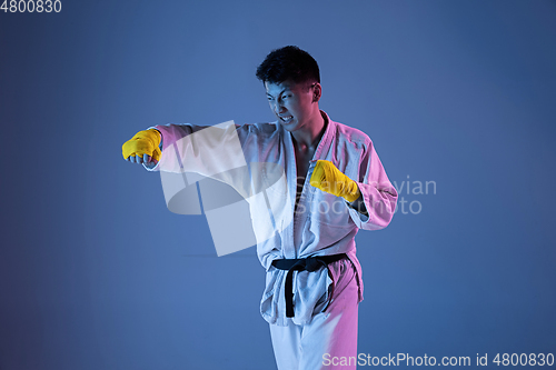 Image of Confident korean man in kimono practicing hand-to-hand combat, martial arts