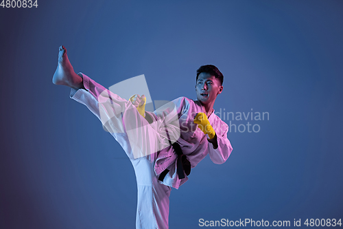 Image of Confident korean man in kimono practicing hand-to-hand combat, martial arts