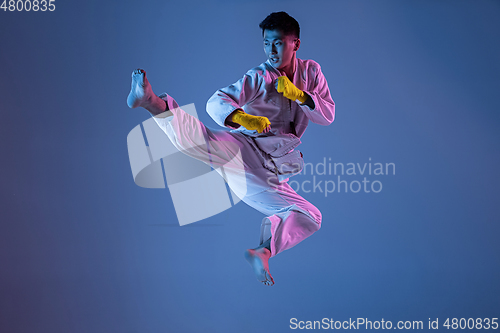 Image of Confident korean man in kimono practicing hand-to-hand combat, martial arts