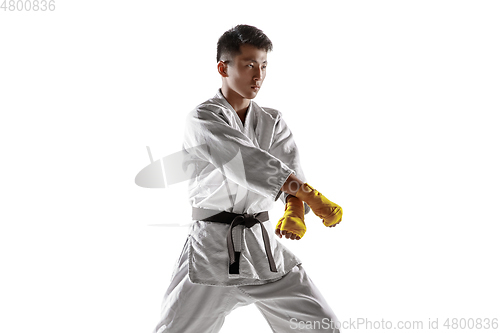 Image of Confident korean man in kimono practicing hand-to-hand combat, martial arts