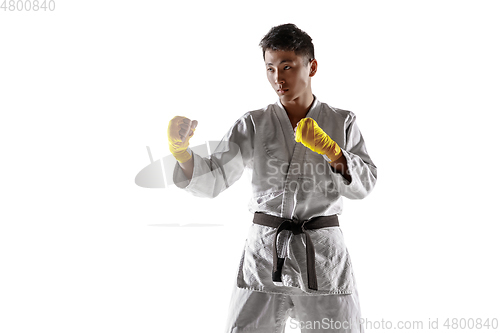 Image of Confident korean man in kimono practicing hand-to-hand combat, martial arts