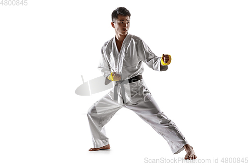 Image of Confident korean man in kimono practicing hand-to-hand combat, martial arts