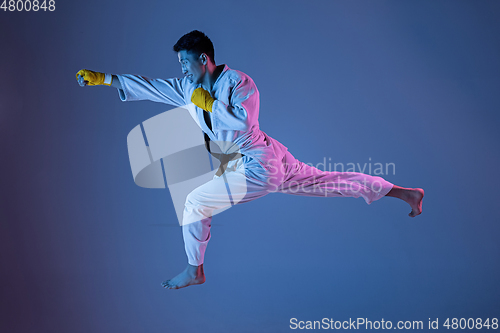 Image of Confident korean man in kimono practicing hand-to-hand combat, martial arts