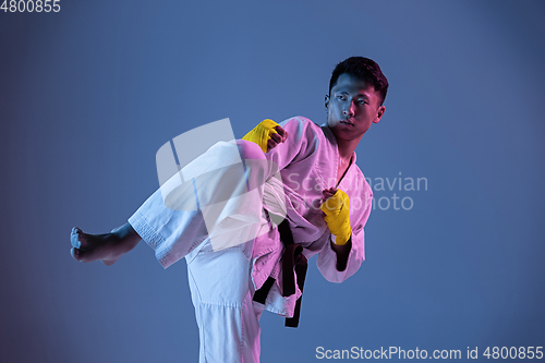 Image of Confident korean man in kimono practicing hand-to-hand combat, martial arts