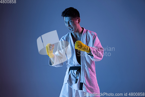 Image of Confident korean man in kimono practicing hand-to-hand combat, martial arts