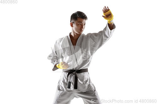 Image of Confident korean man in kimono practicing hand-to-hand combat, martial arts