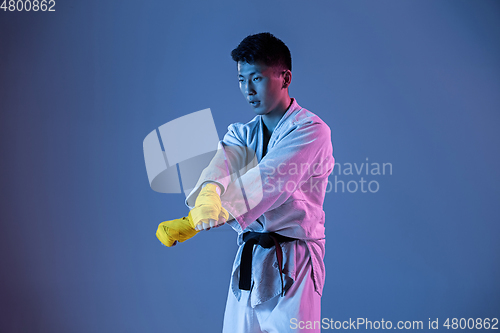 Image of Confident korean man in kimono practicing hand-to-hand combat, martial arts