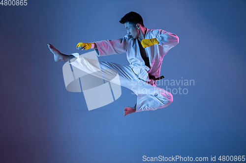 Image of Confident korean man in kimono practicing hand-to-hand combat, martial arts